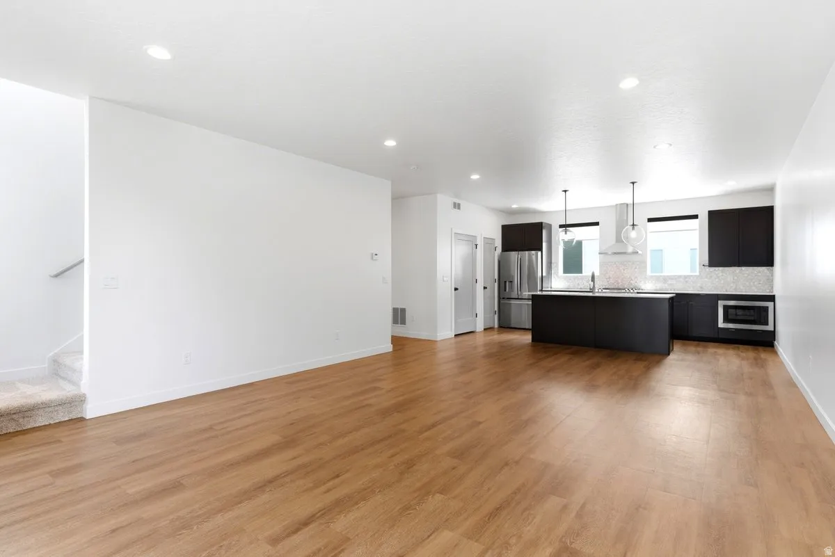 Open-concept living space featuring wood-finish flooring and recessed lighting