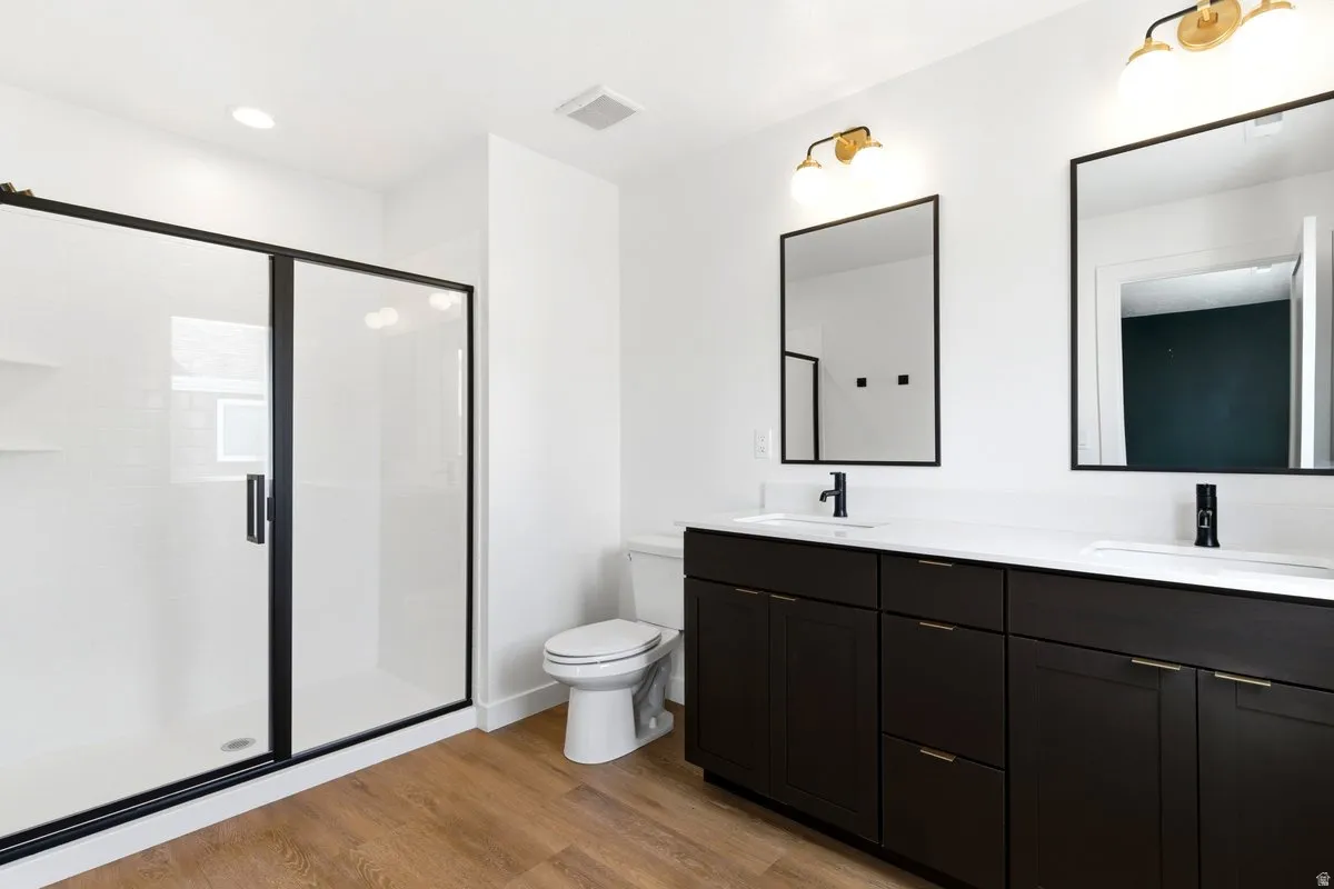Contemporary bathroom featuring a dual vanity with dark wood-finish cabinetry, white countertops, and matte black fixtures