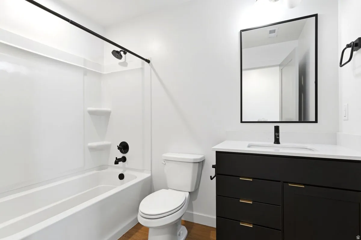 Bathroom featuring a black vanity with gold-tone hardware, white countertop, and integrated sink