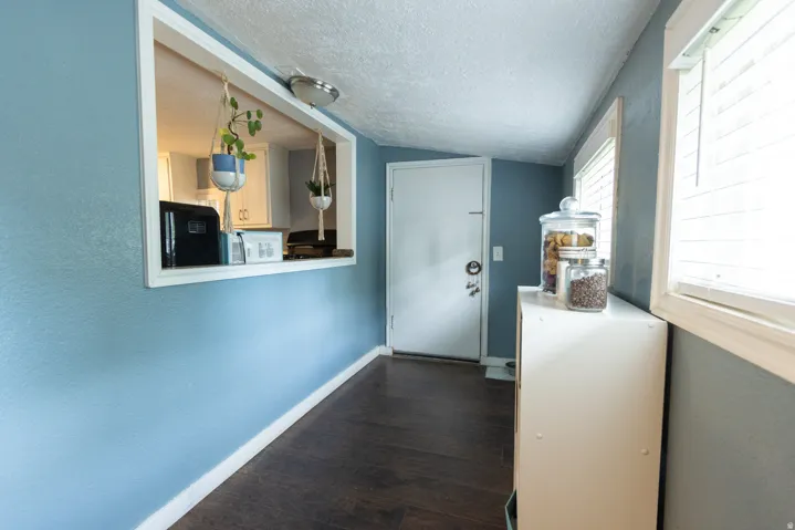 Entryway featuring dark wood-finish flooring, light blue walls, and white trim