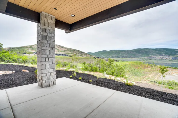 Covered outdoor patio with a stone-clad pillar and concrete flooring