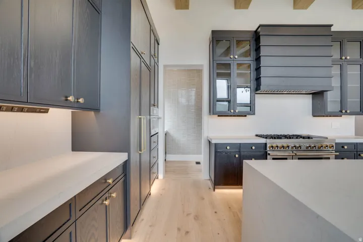 Gourmet kitchen featuring dark wood cabinetry, light countertops, and a professional-grade range with a custom range hood