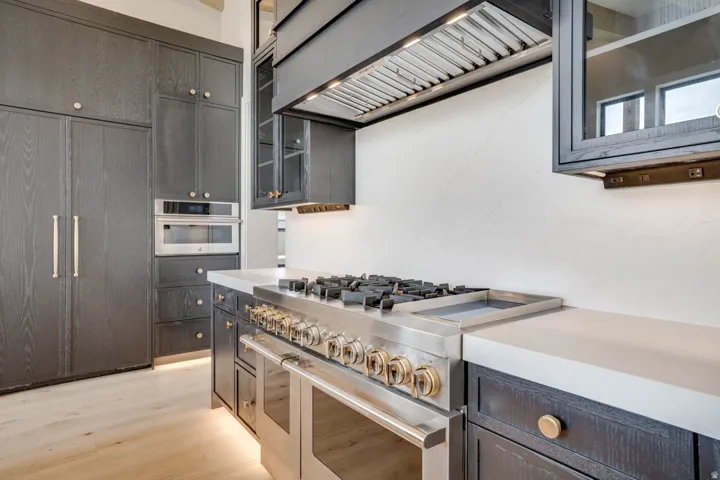 Gourmet kitchen featuring a stainless steel range with multiple burners, integrated oven, and a professional-grade range hood