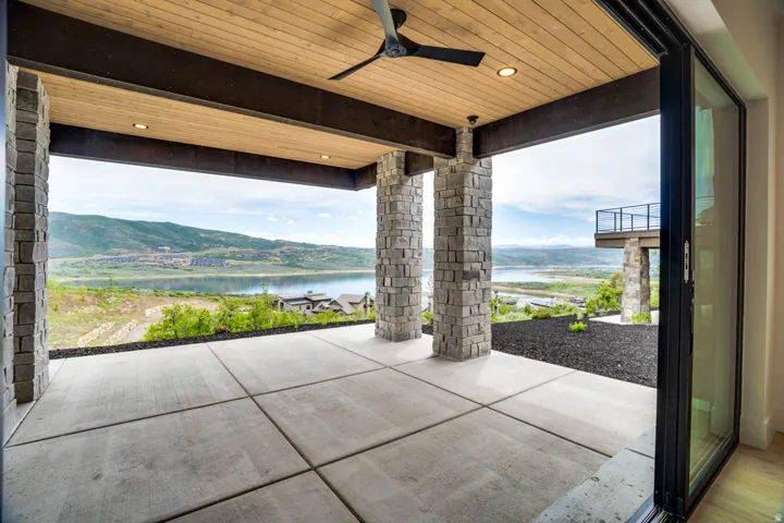 Expansive outdoor patio featuring large format concrete pavers and stone-clad columns