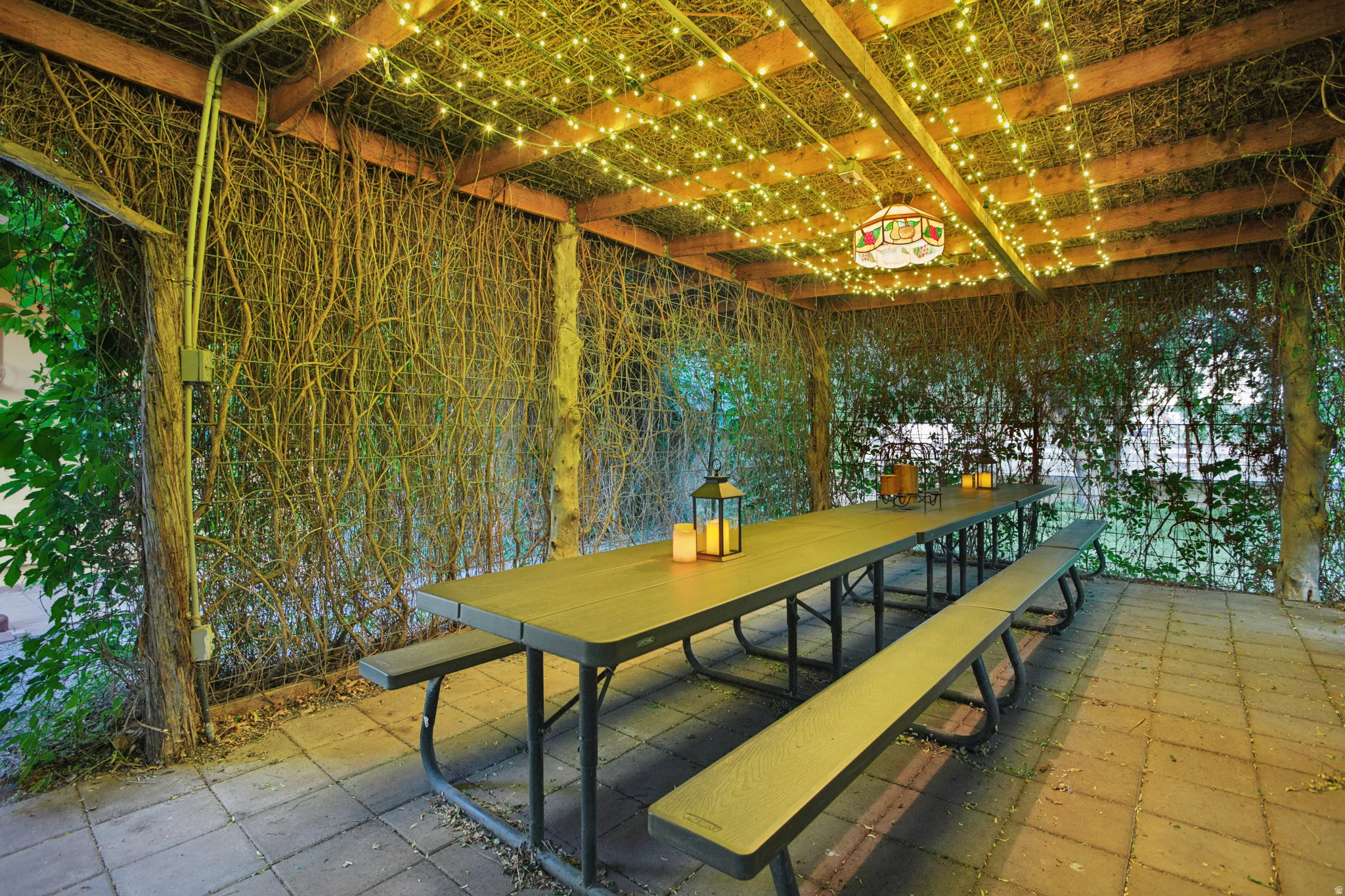 Covered patio featuring a wood beam pergola with integrated string lighting