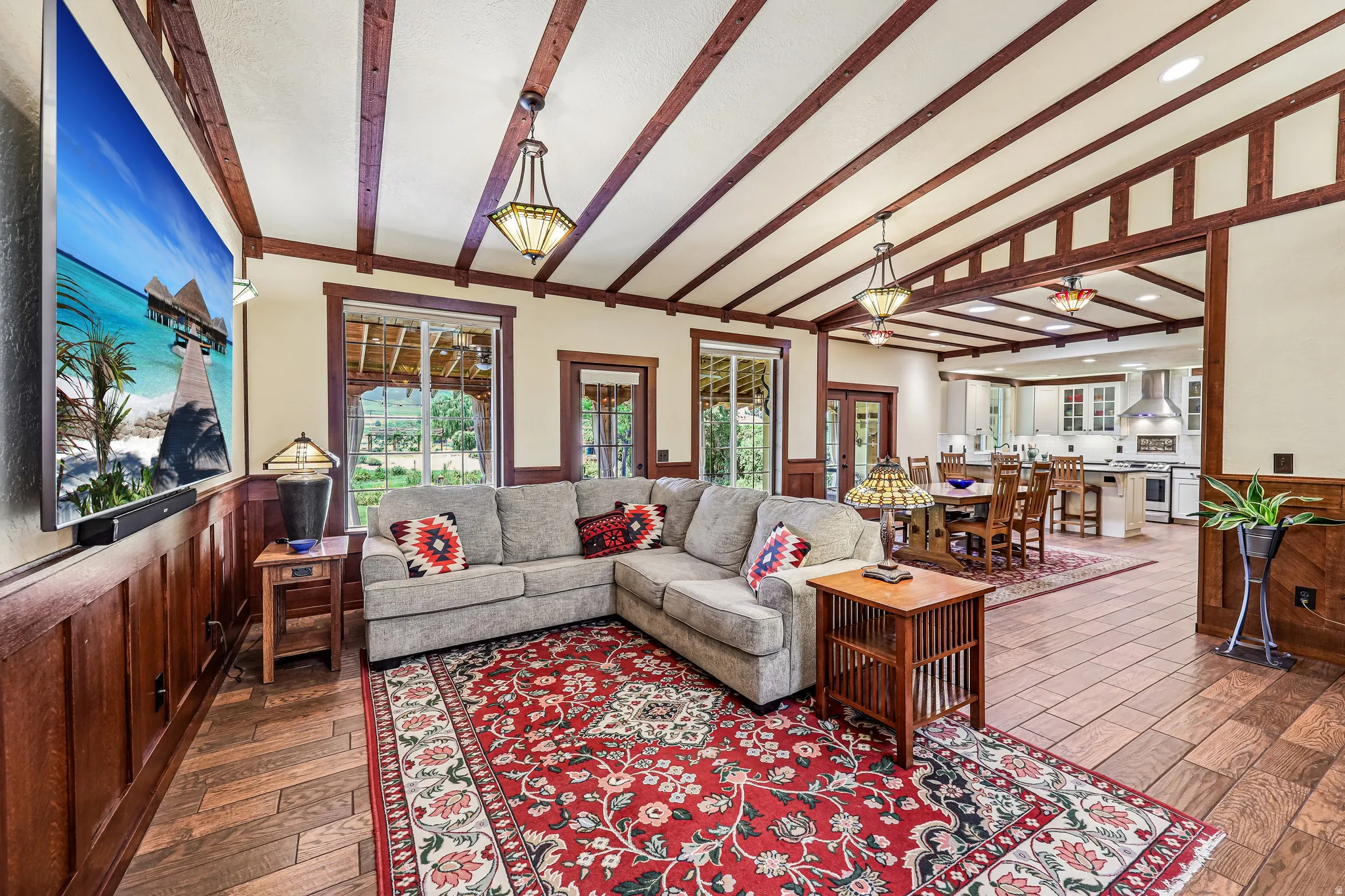 Living area featuring an open concept design, wood-finish flooring, and exposed ceiling beams
