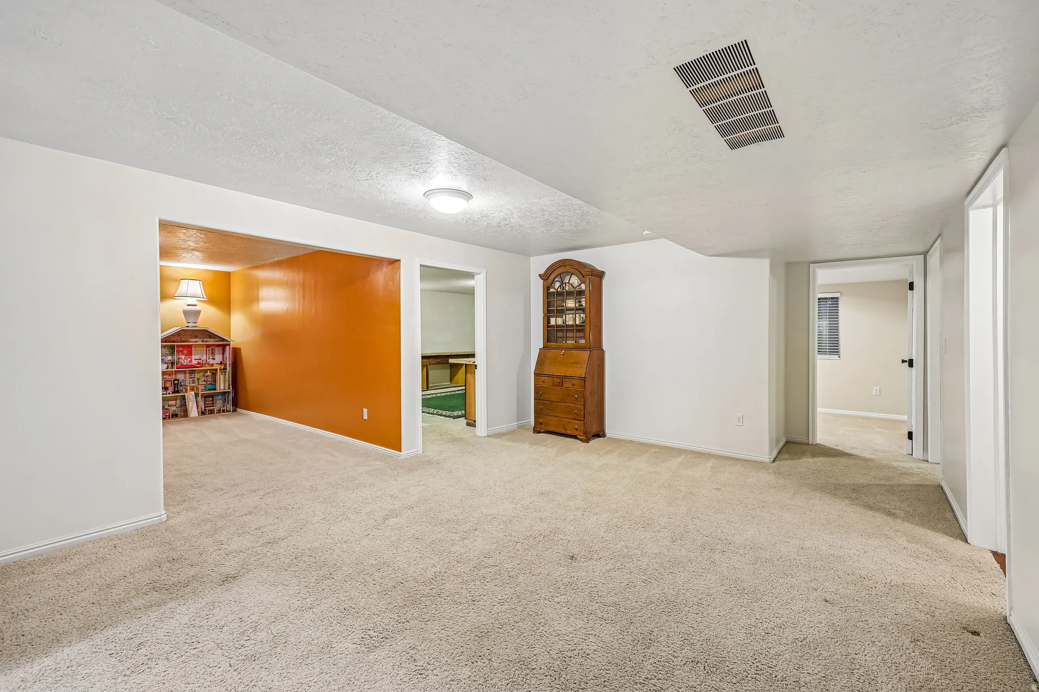 Carpeted entertainment room with overhead lighting