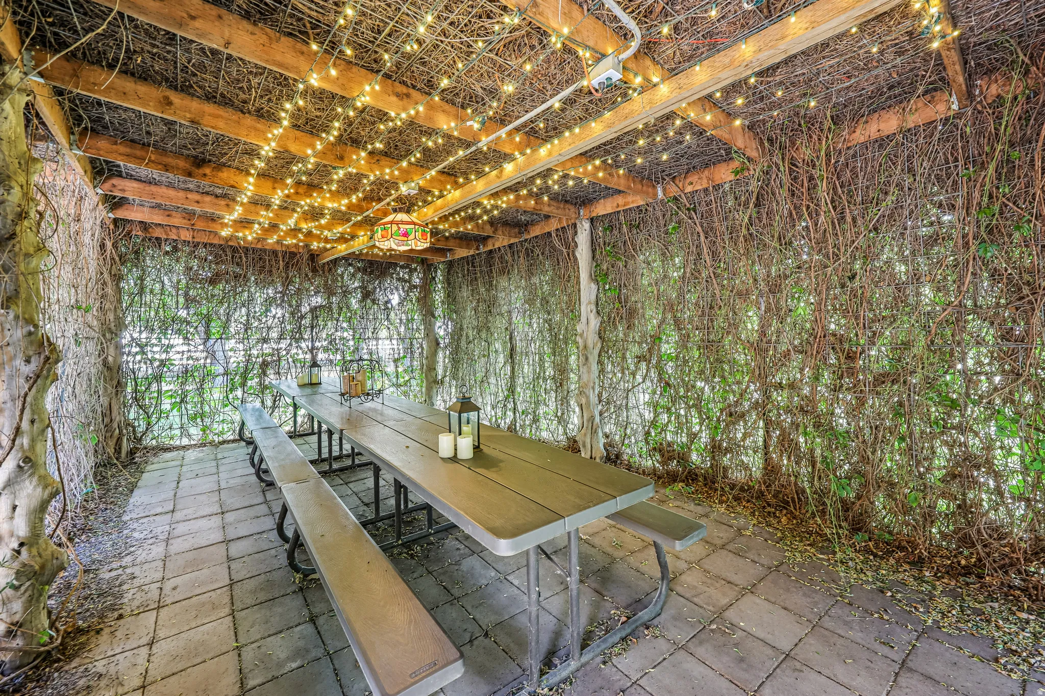 Covered patio area featuring a paver stone floor and a wood beam ceiling