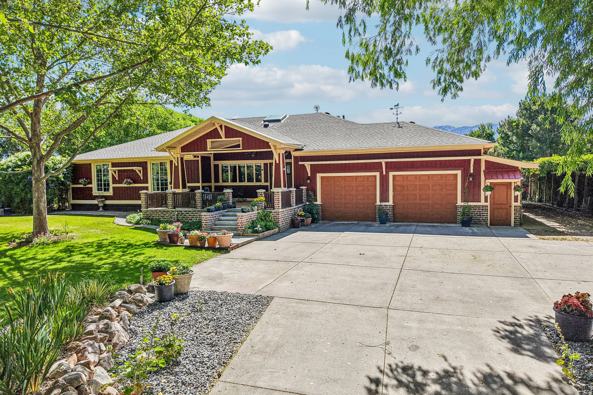 Red-sided residence featuring a covered front porch with stone columns and steps