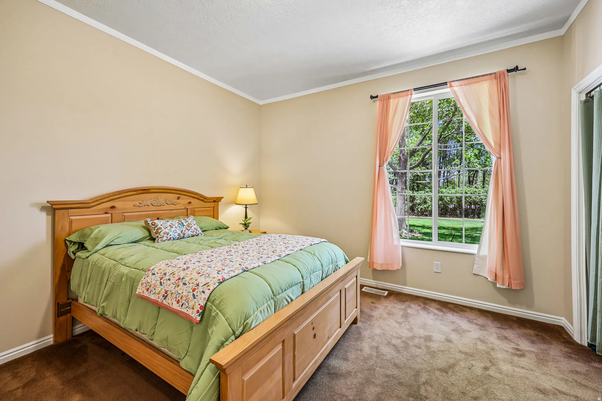 Bedroom featuring a large window, brown carpeting, and neutral wall paint
