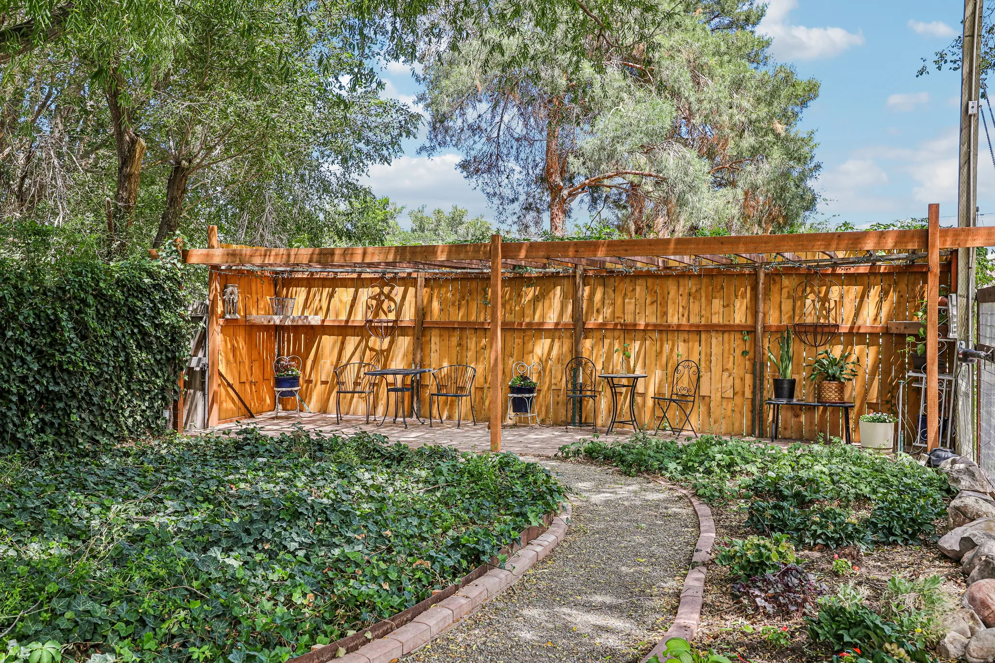 Outdoor patio area featuring a wooden pergola and privacy fence