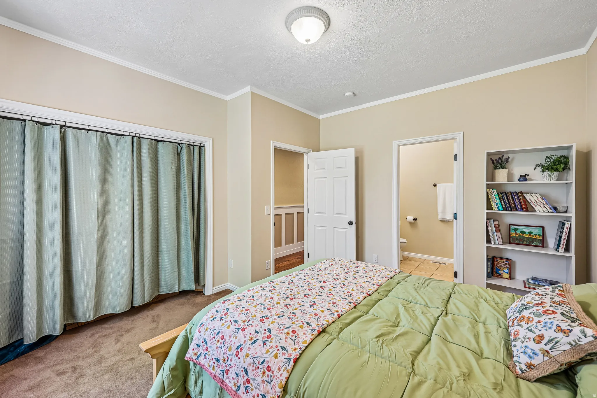 Bedroom featuring neutral wall color, crown molding, and carpet flooring