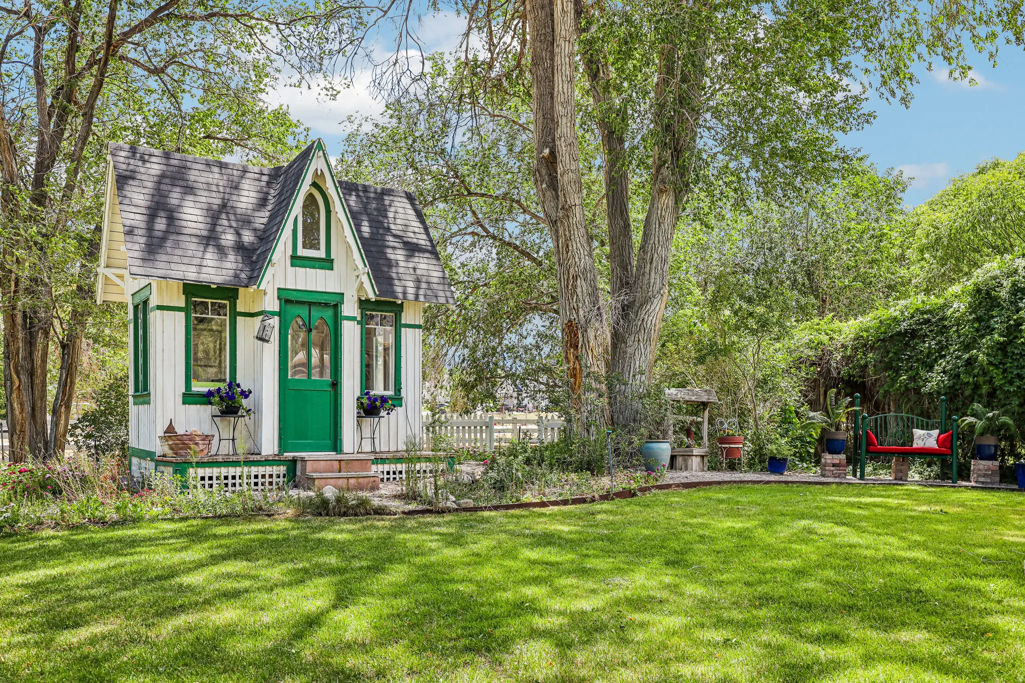 Gabled architectural accent building with dark shingle roof and green trim