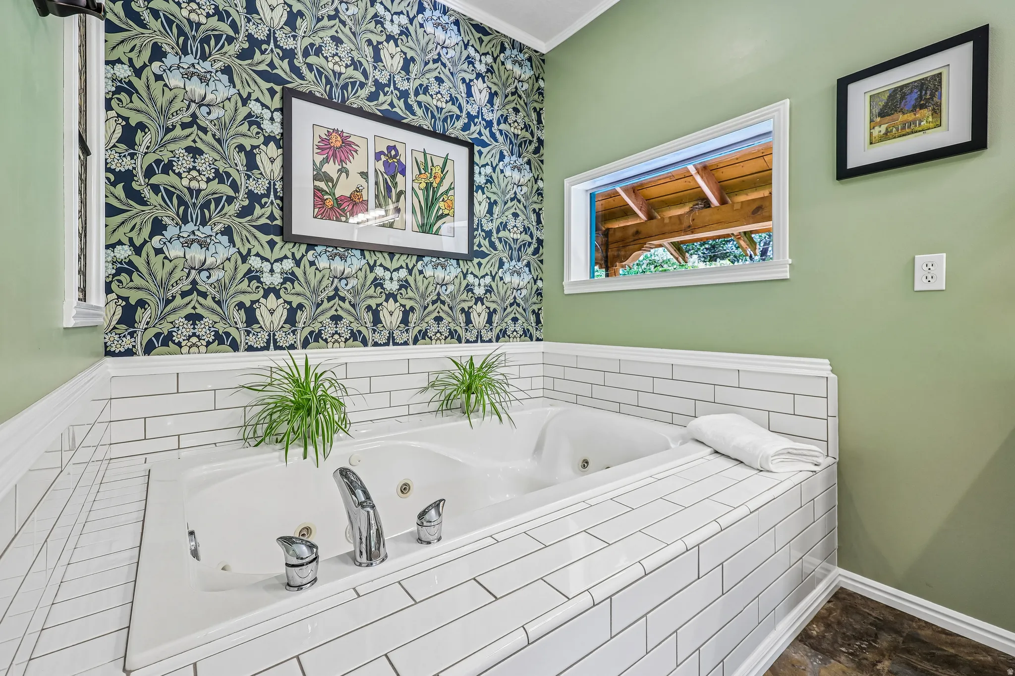 Built-in jetted tub surrounded by white subway tile, featuring chrome fixtures and a window overlooking a covered outdoor structure