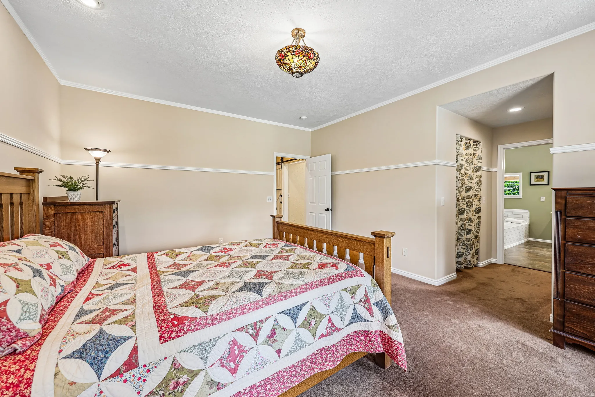Bedroom featuring wall-to-wall carpeting, crown molding, and chair rail detailing