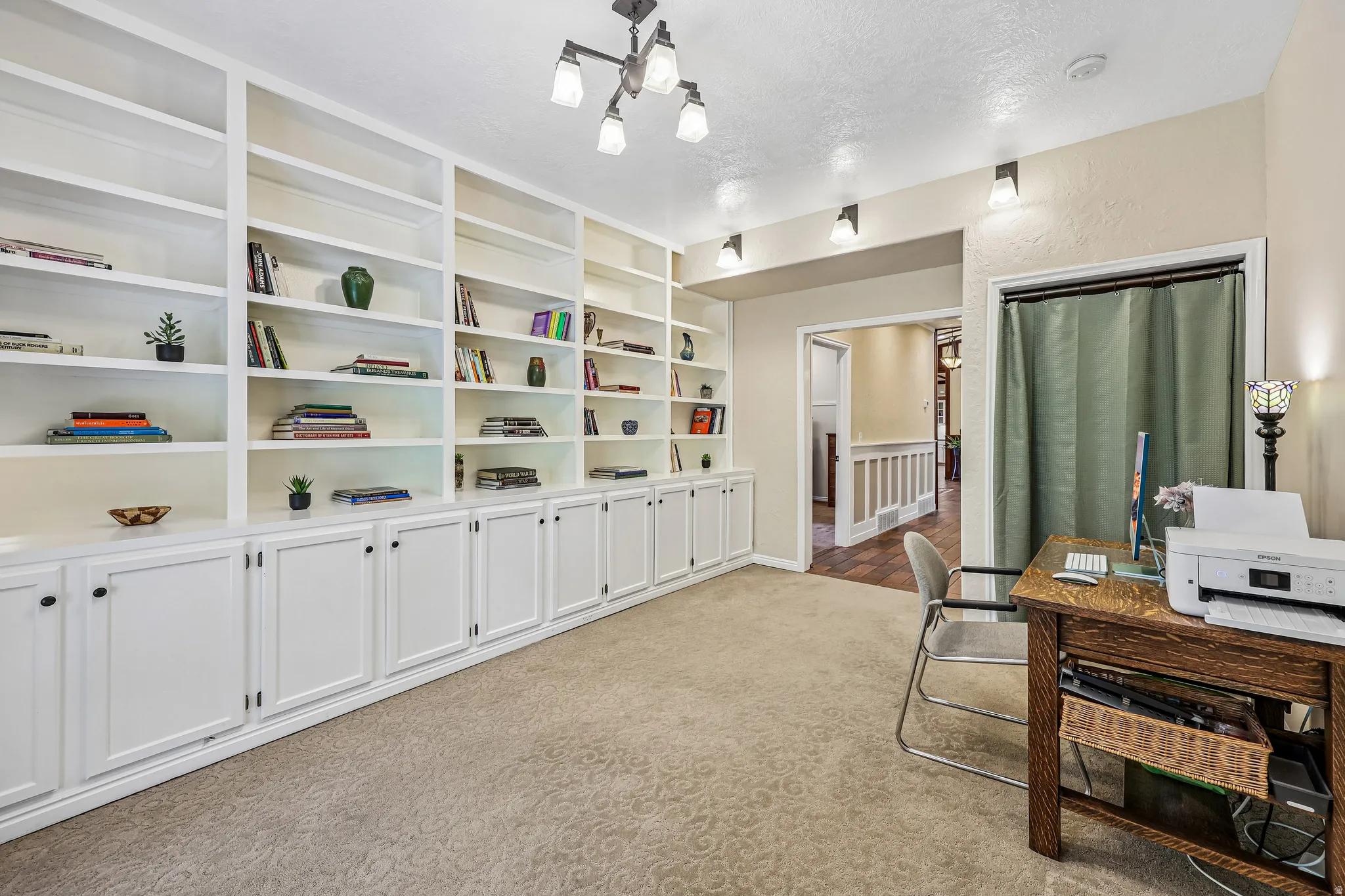 Extensive built-in shelving and cabinetry with a neutral-toned carpet