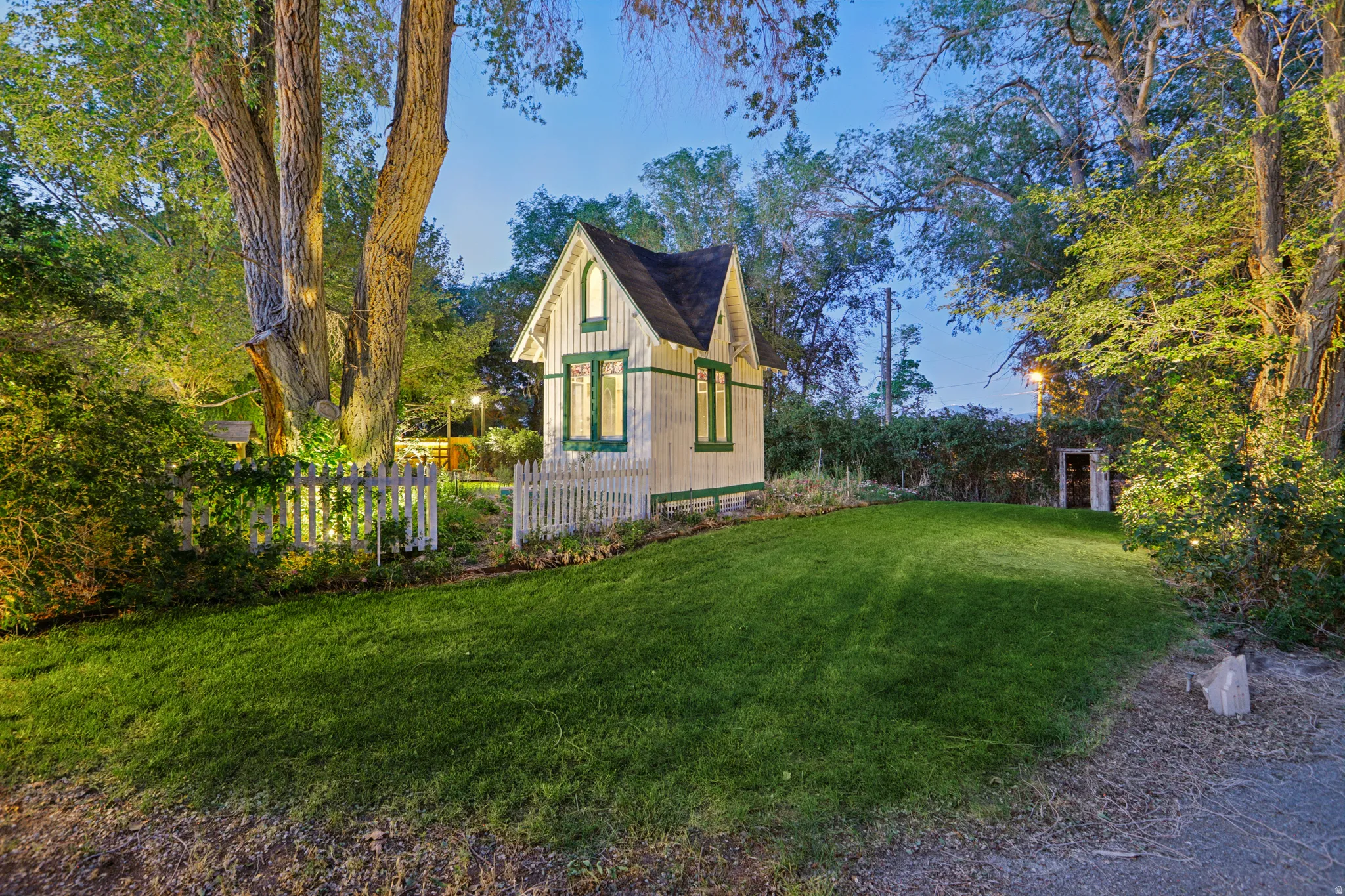 Charming cottage-style structure featuring a gabled roof and green trim accents