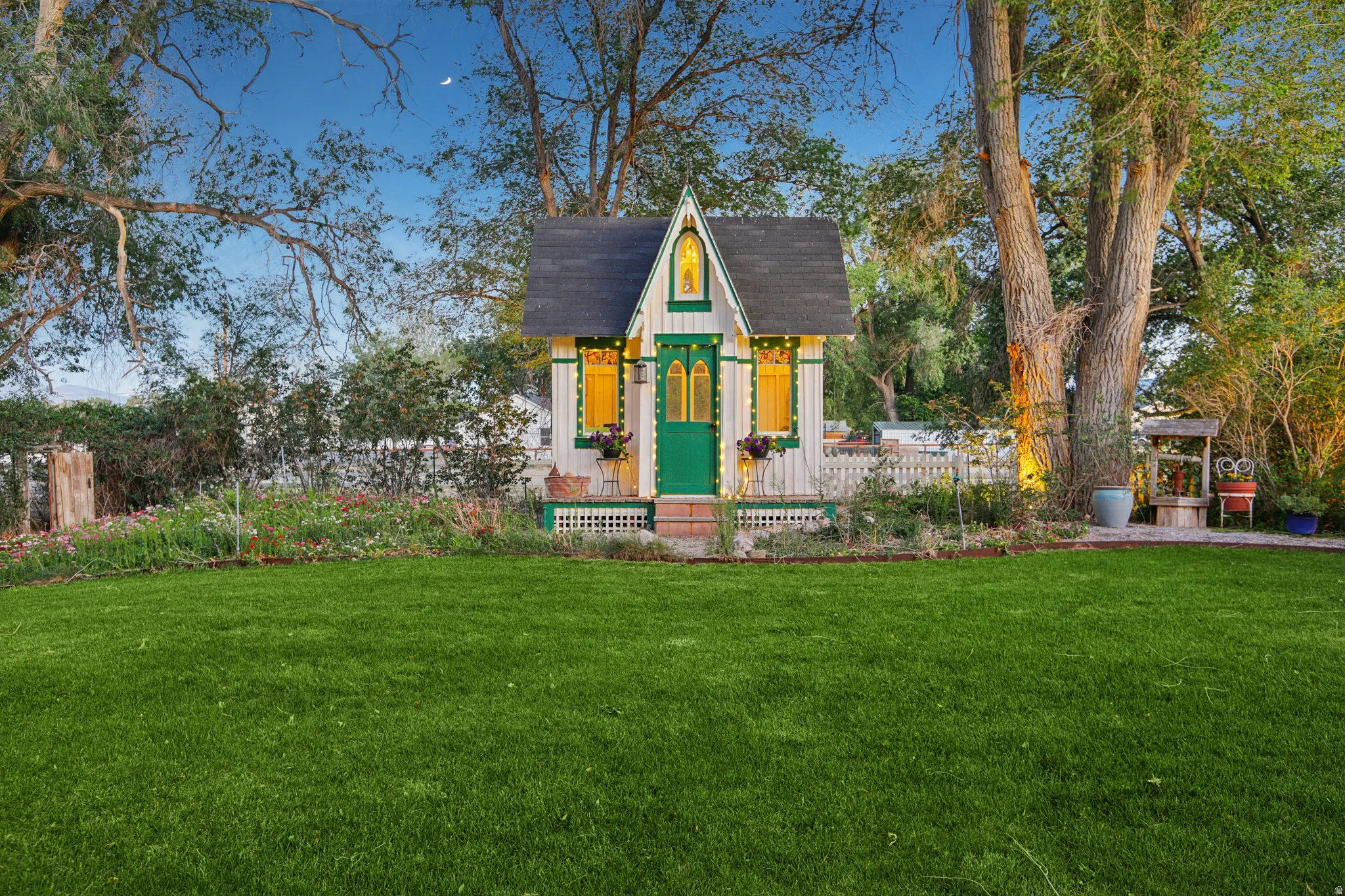 Charming playhouse featuring a steeply pitched roof, decorative trim, and a vibrant green door