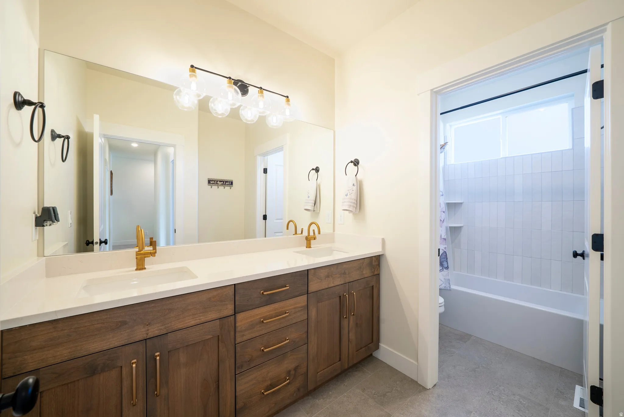 Double vanity with wood-finish cabinetry and gold-tone hardware