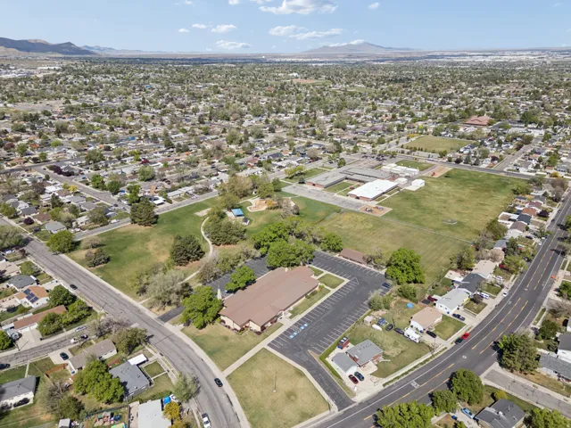 Residential neighborhood featuring mature trees, paved streets, and a large green space.