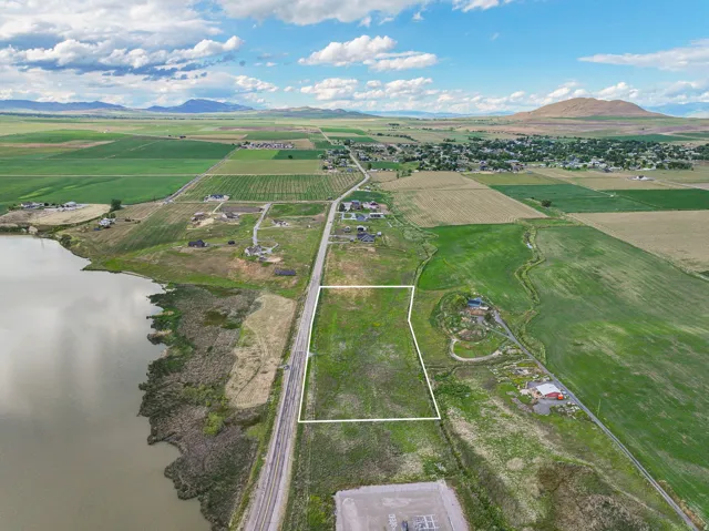 Expansive land parcel with direct road frontage, bordering railway tracks, and offering distant mountain scenery