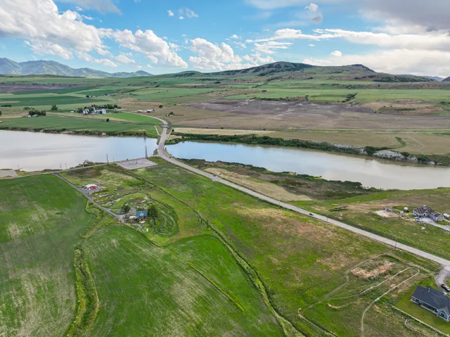 Expansive rural landscape featuring a prominent river, a connecting bridge, and a winding roadway