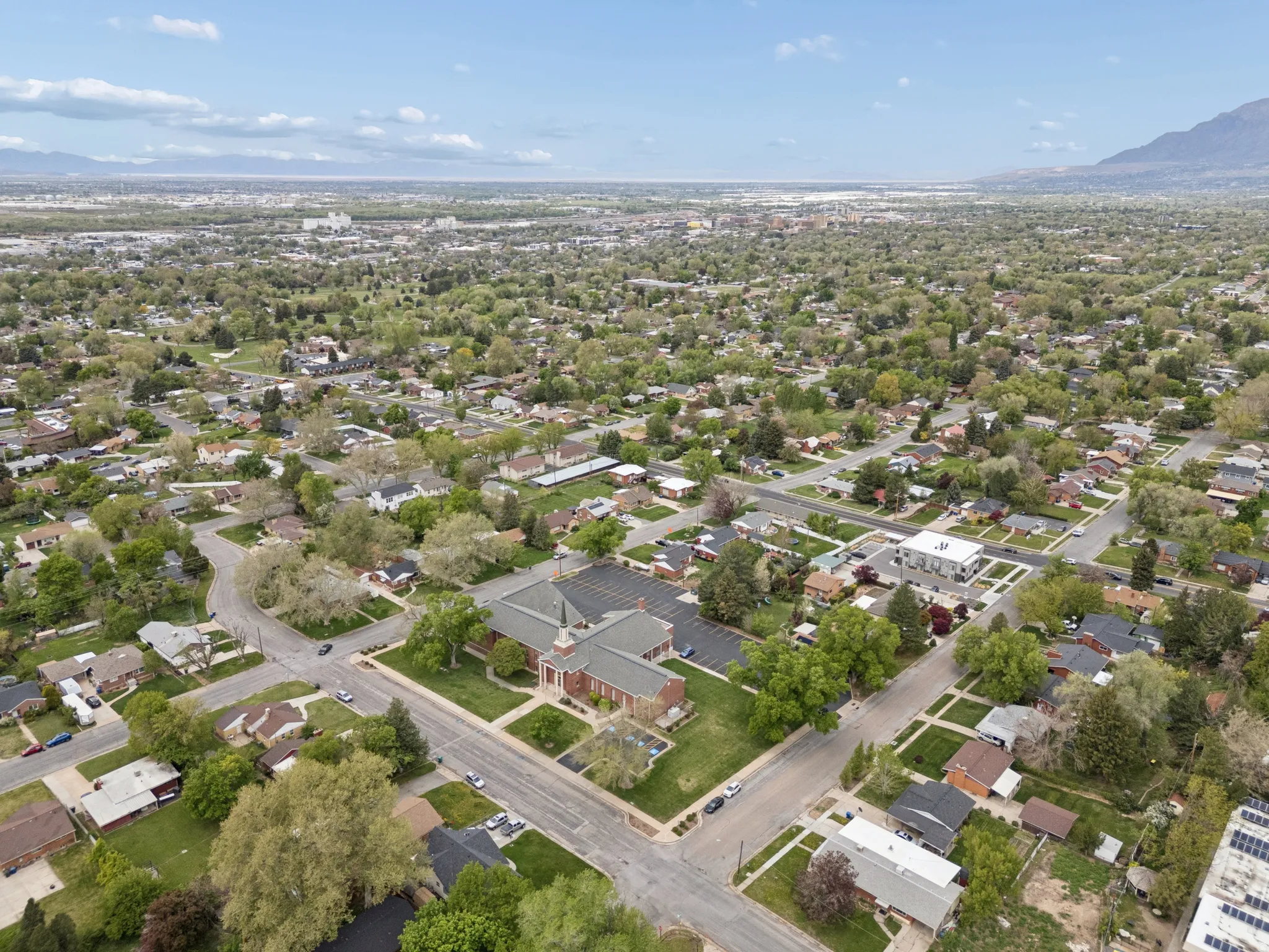 Residential neighborhood featuring mature trees and a distant mountain range.