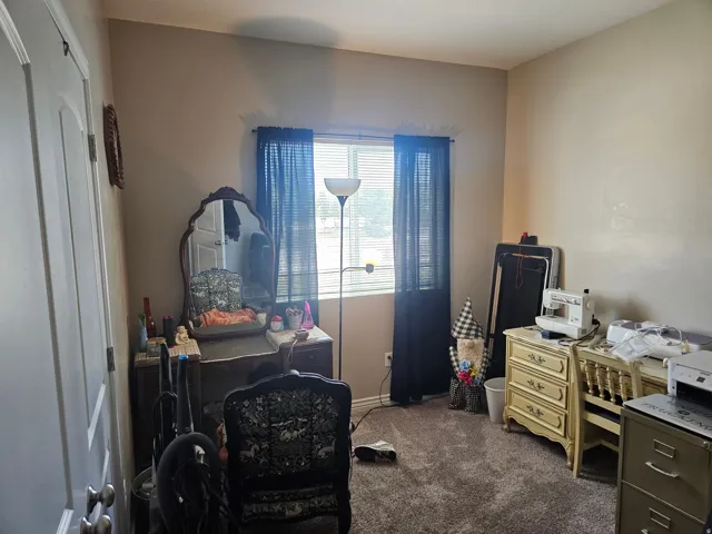 Room featuring a window with horizontal blinds, neutral wall paint, and gray carpet flooring