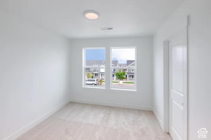 Neutral-toned wall-to-wall carpeting, dual-pane windows, recessed ceiling lighting, and a solid-core interior door