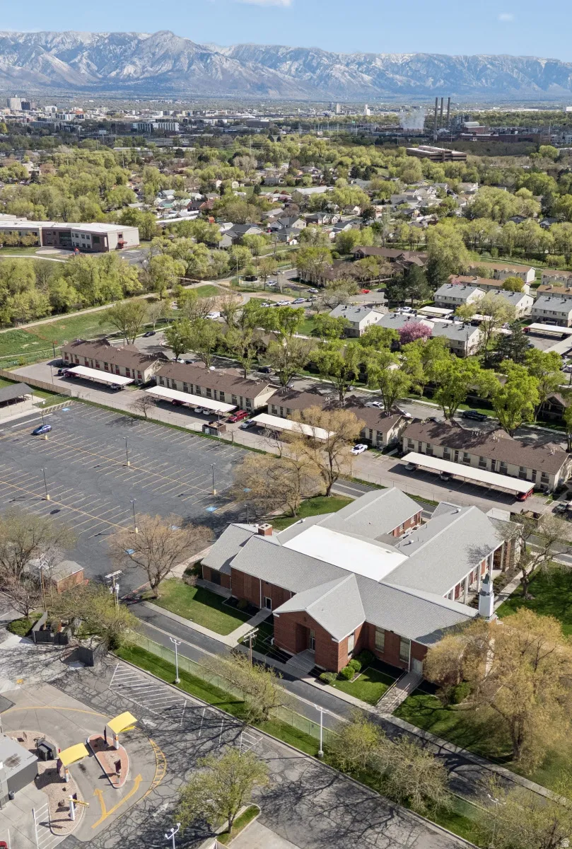 U-shaped commercial building featuring a brick facade and light gray roofing.