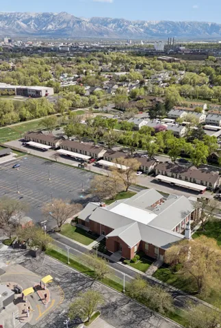 U-shaped commercial building featuring a brick facade and light gray roofing.