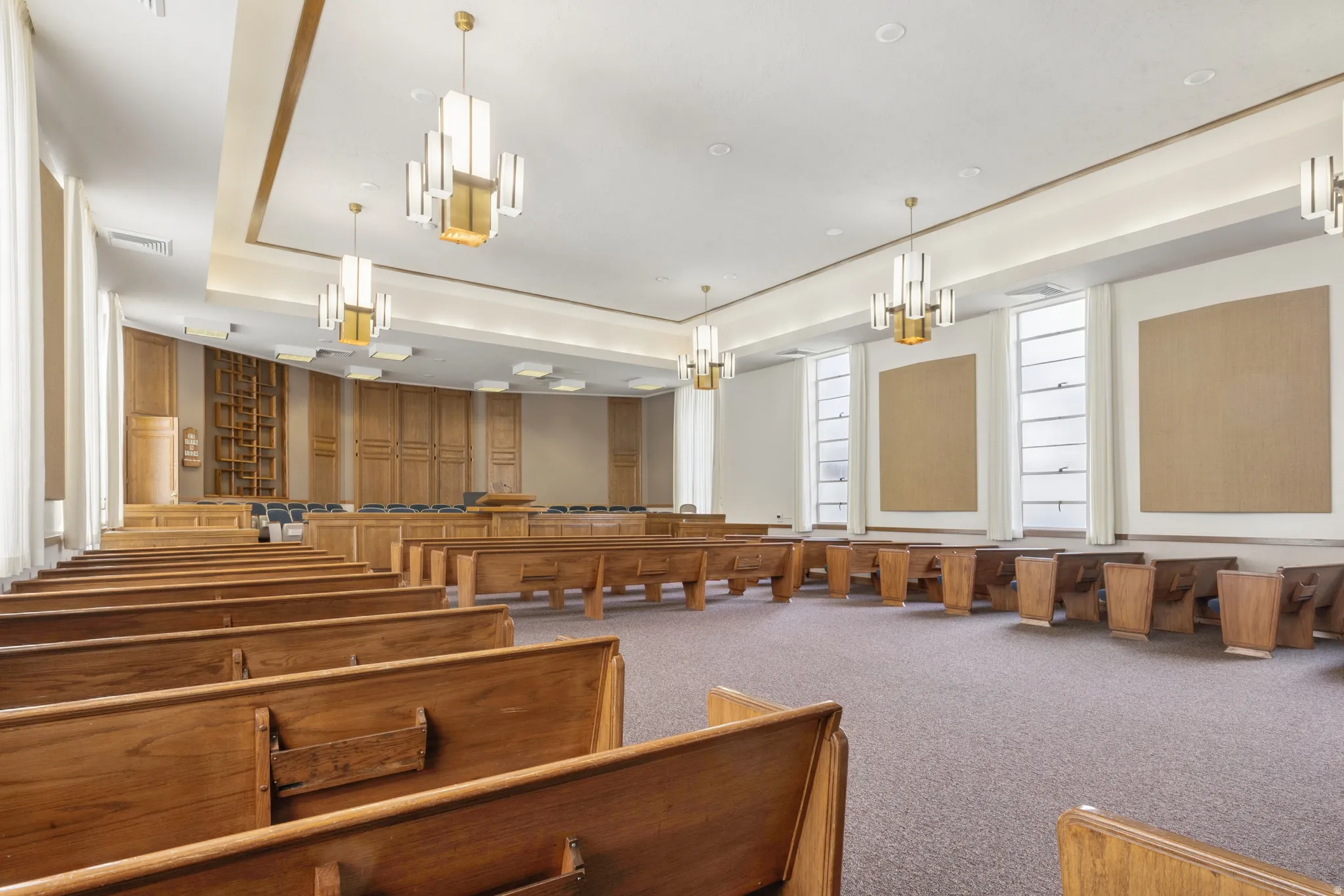 Spacious hall featuring high ceilings with recessed lighting and decorative chandeliers.