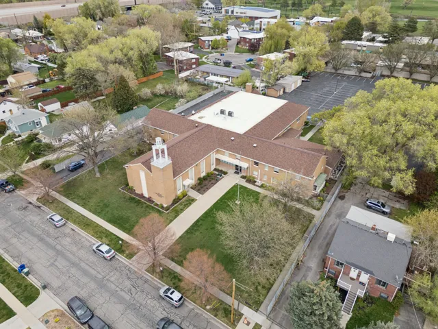 Expansive institutional building with a prominent steeple, brick facade, and a multi-gabled roof.
