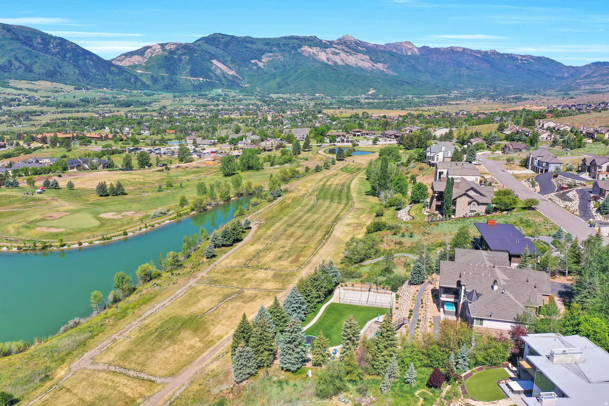 Aerial perspective showcasing surrounding properties, a prominent body of water, and distant mountains