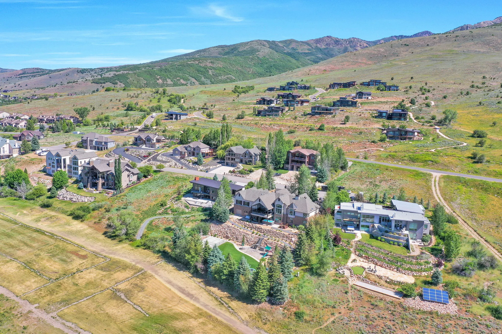 Expansive mountain landscape featuring multiple custom residences and abundant natural terrain