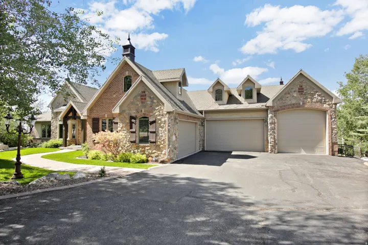 Stone and brick exterior with a prominent asphalt driveway