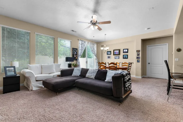 Open-concept living area featuring neutral-toned carpeting and walls