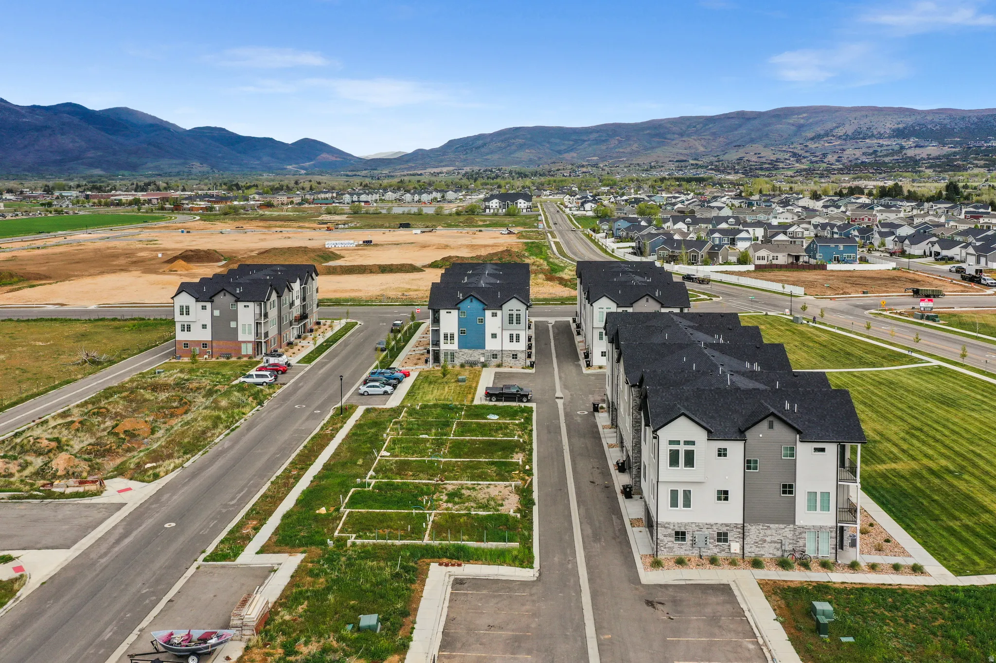 New construction townhomes featuring contemporary facades with stone and siding accents, dark shingle roofing, and private balconies
