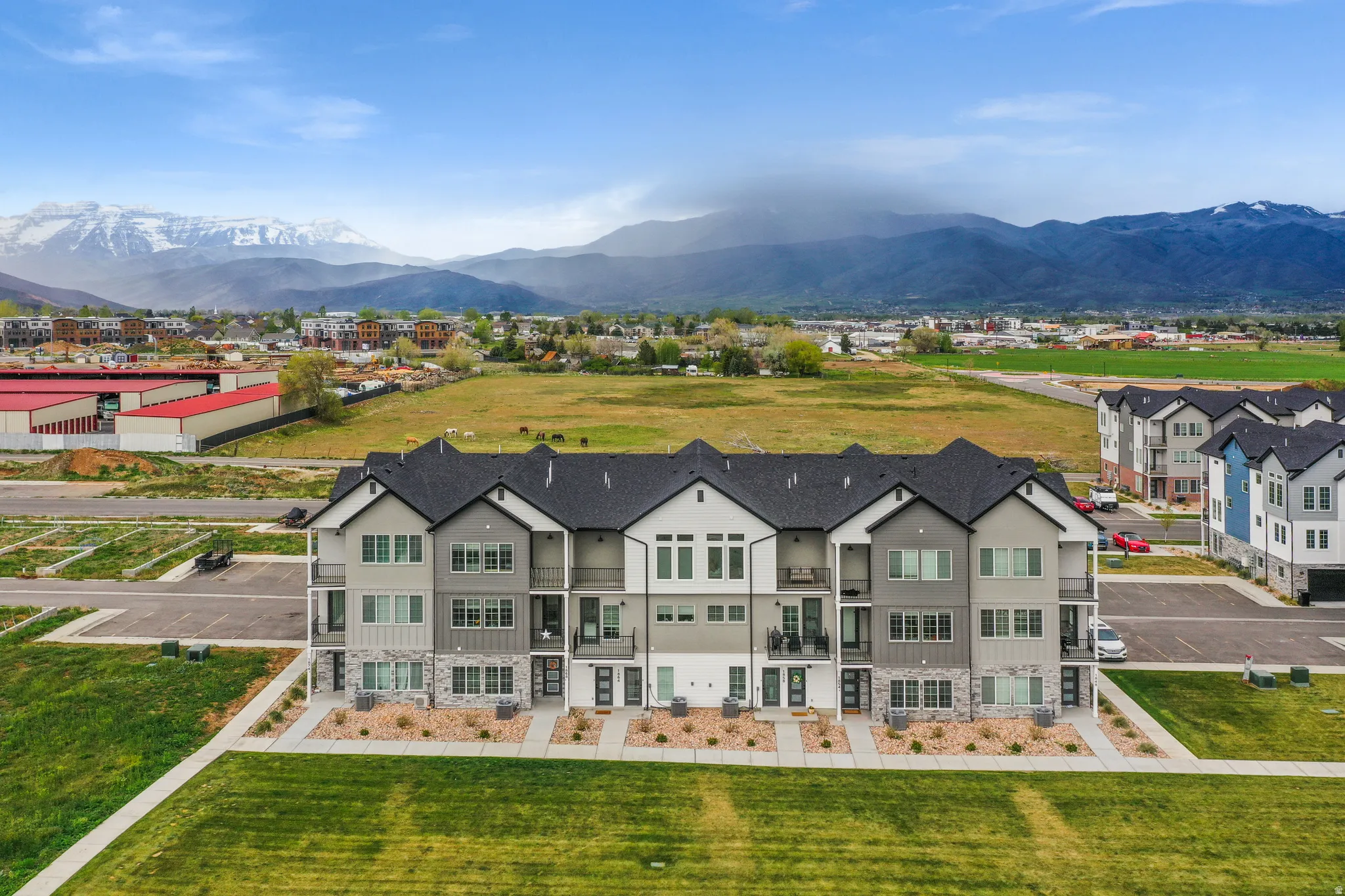 Contemporary townhome-style residences featuring multi-level construction, balconies, and a blend of siding and stone facade