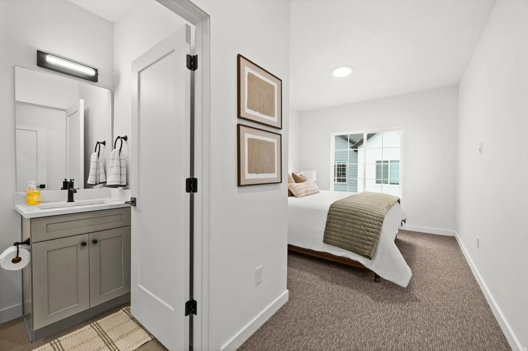 Bathroom vanity with a rectangular undermount sink, black faucet, and white quartz countertop