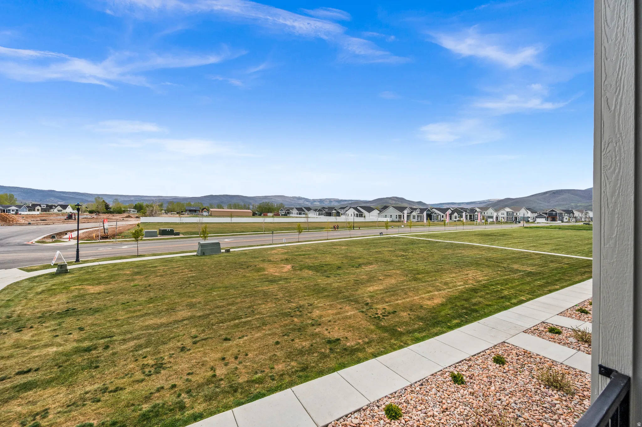 Expansive open green space with concrete pathways and decorative rock landscaping