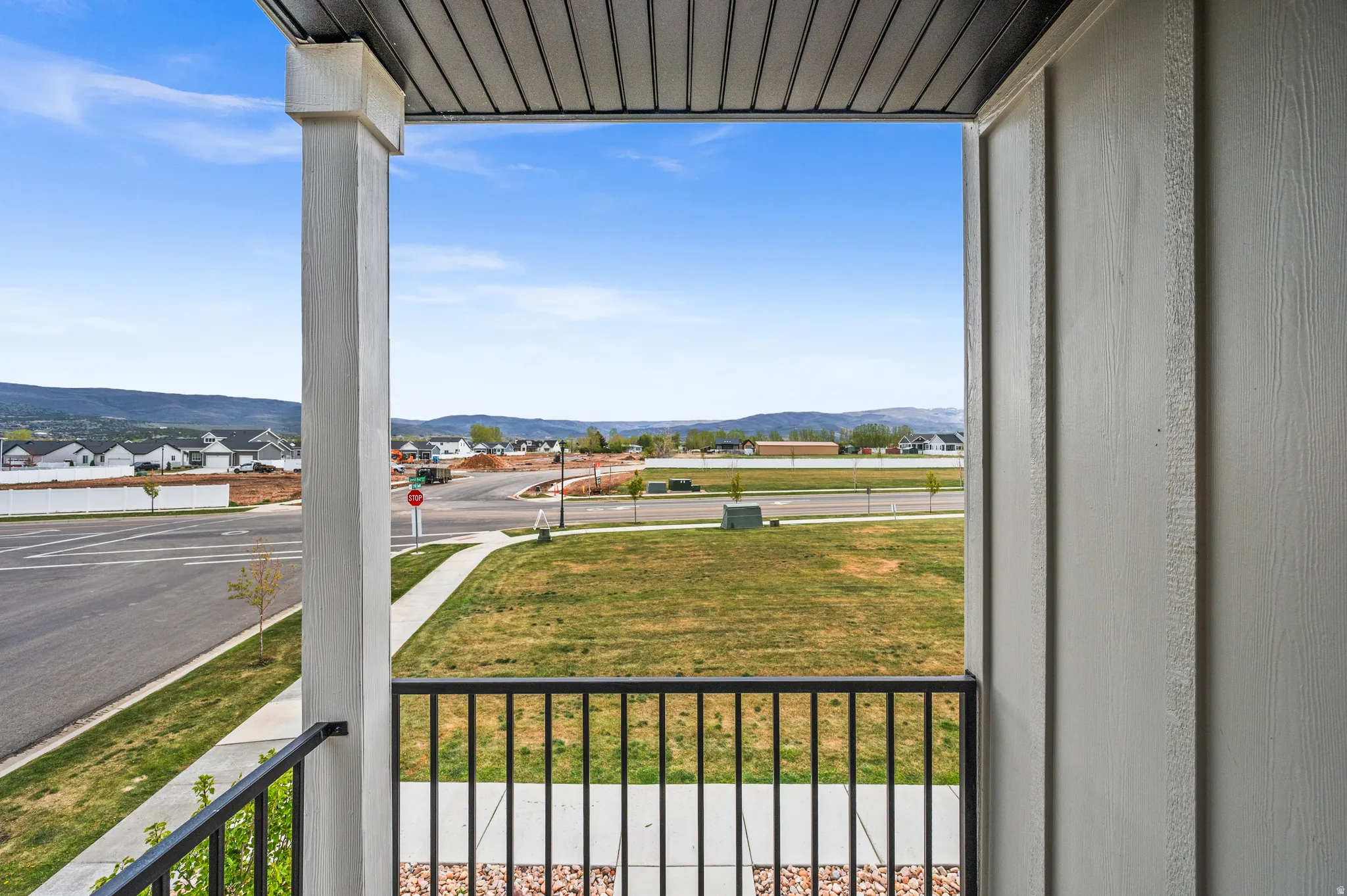 Balcony featuring a black metal railing, a solid white structural column, and a dark soffit ceiling