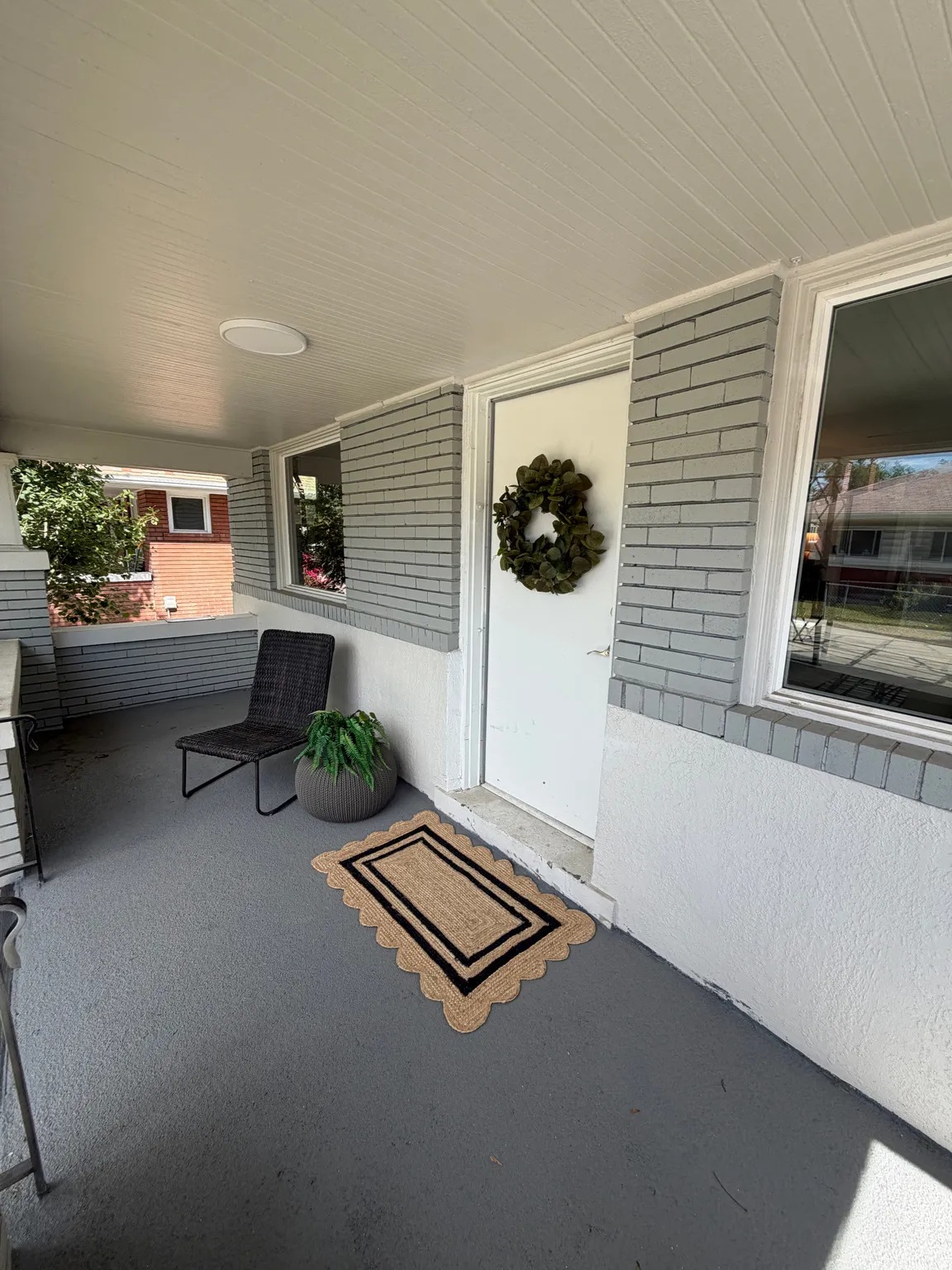 Covered porch featuring a painted concrete floor