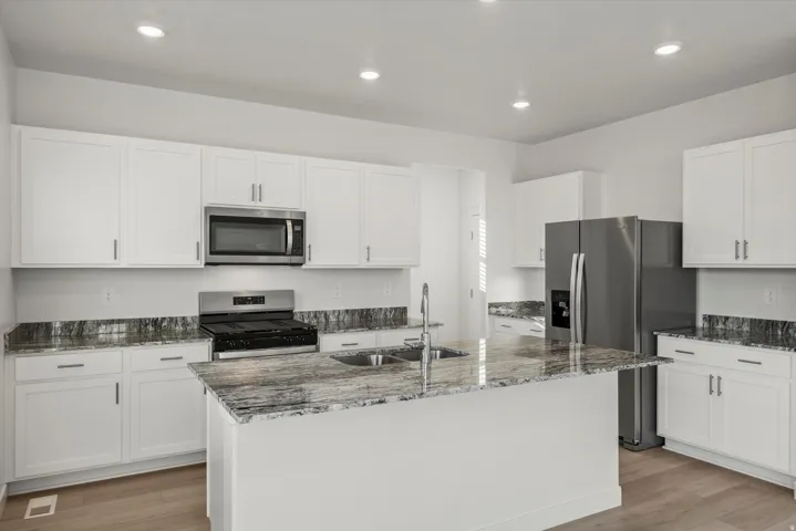 Kitchen featuring a central island with an undermount sink and faucet