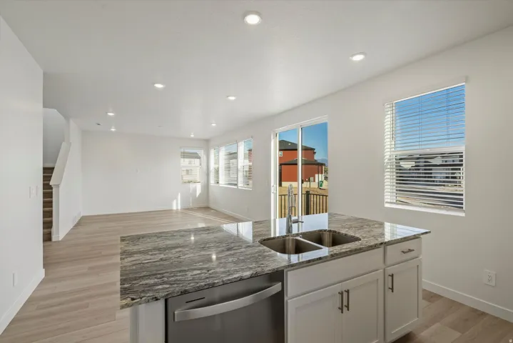 Kitchen island featuring a dual basin sink, stainless steel faucet, and granite countertop