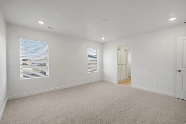 Spacious room featuring neutral carpeting and white walls