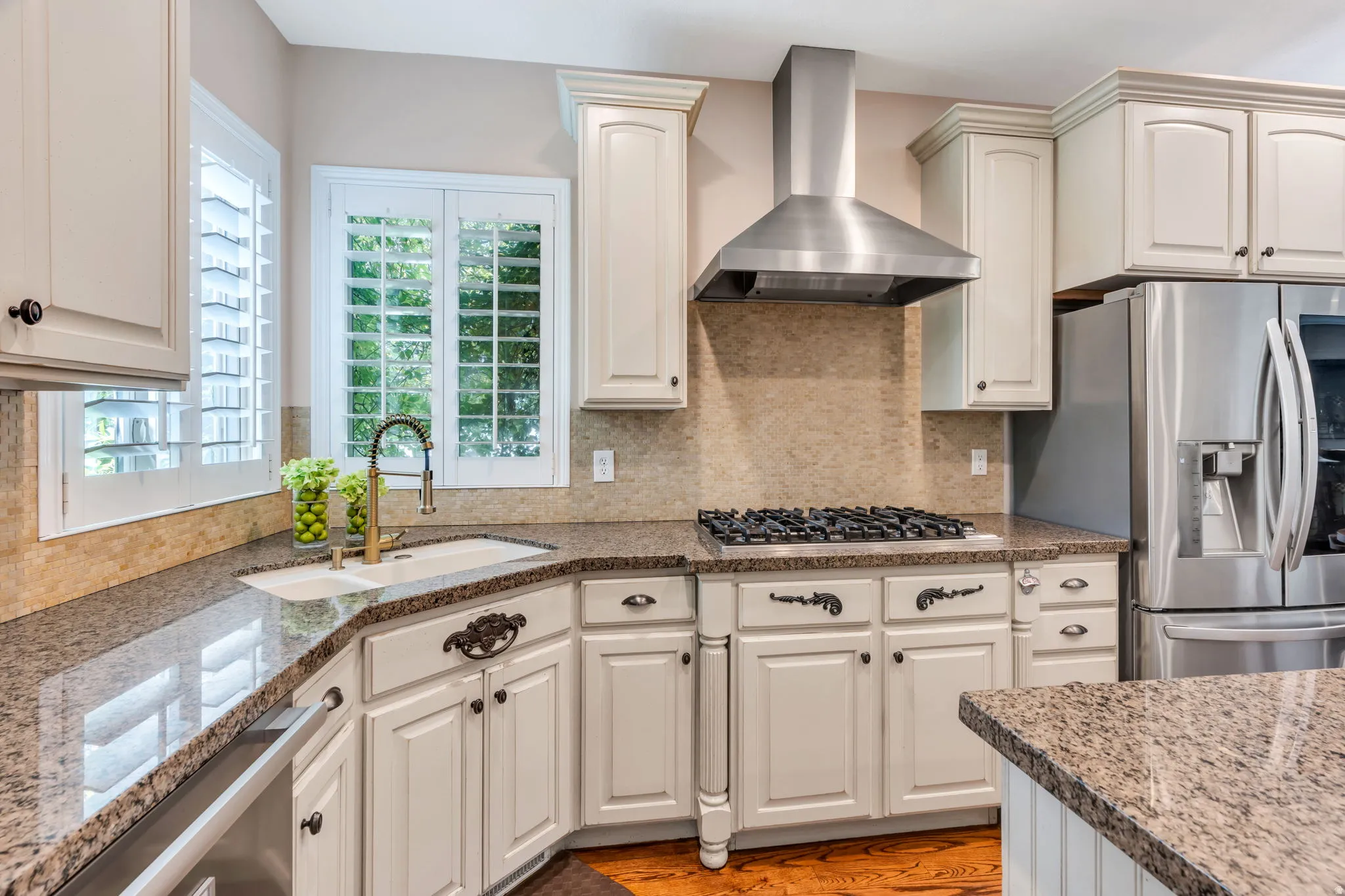 Kitchen featuring a gas range, stainless steel appliances, granite countertops, and white cabinetry with decorative hardware