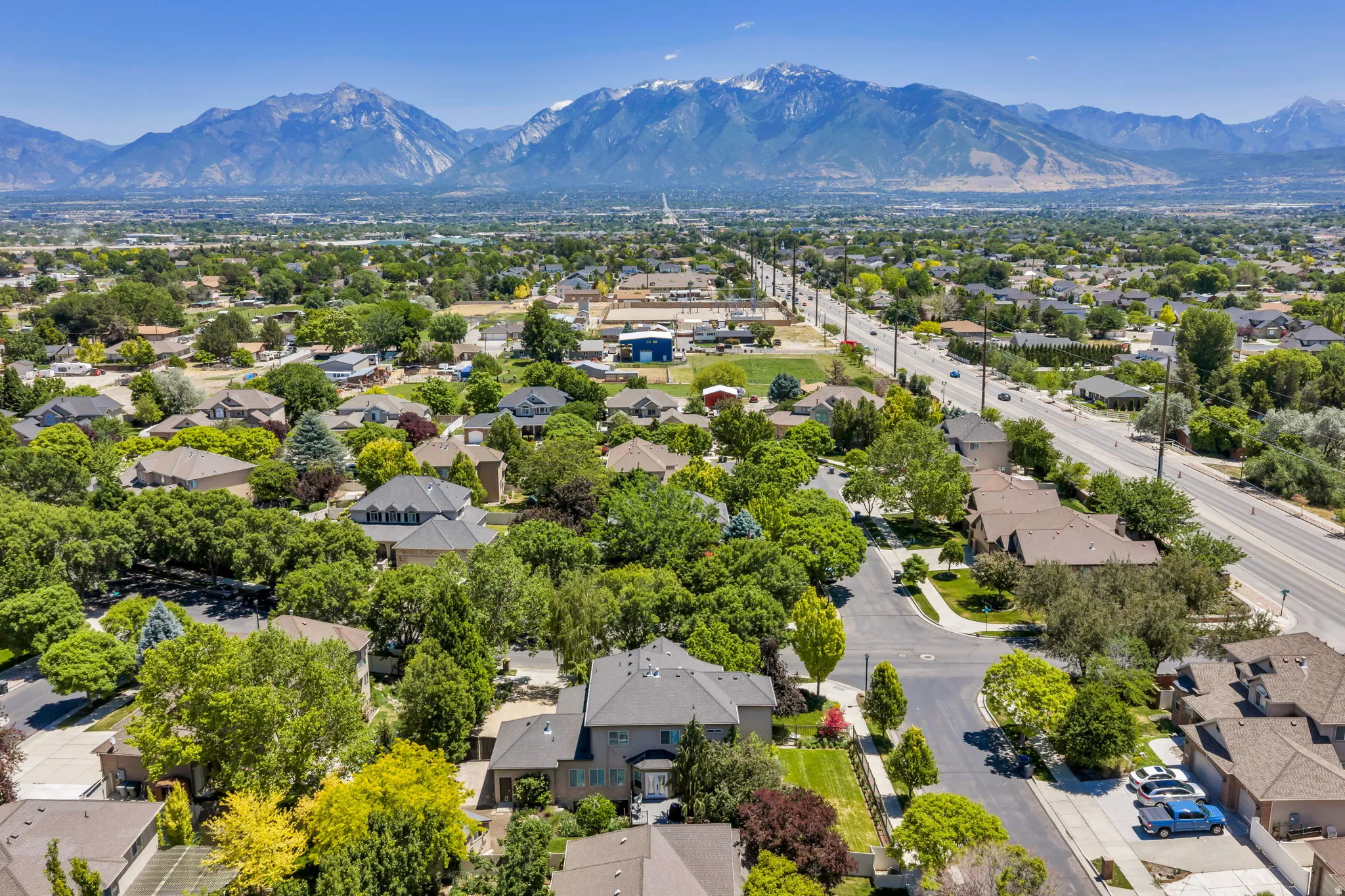 Expansive residential area featuring established homes, mature trees, and mountainous terrain in the distance