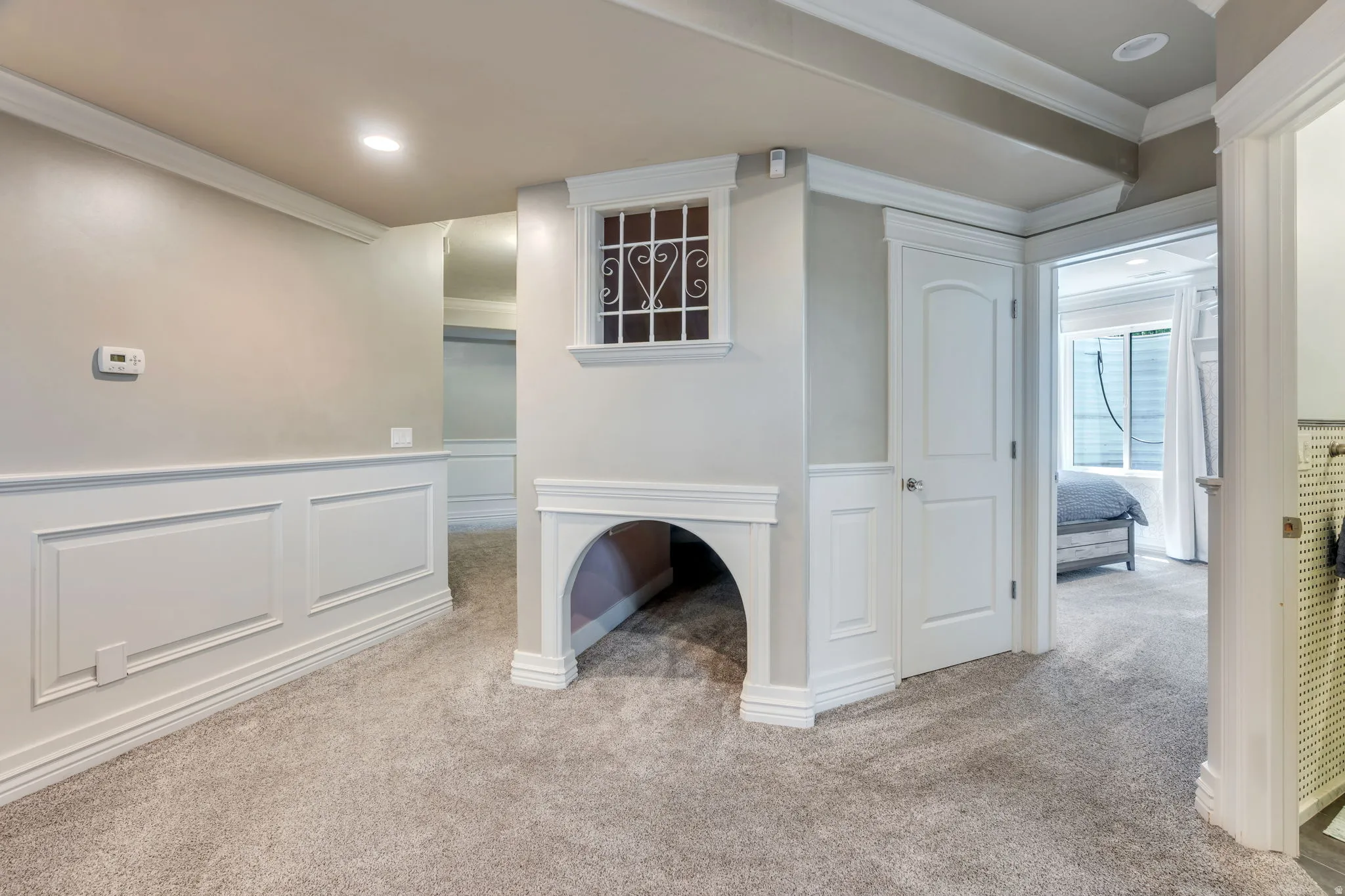 Carpeted room featuring wainscoting, crown molding, and recessed lighting