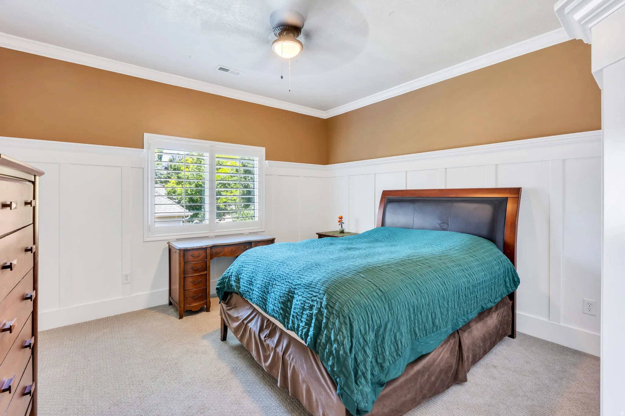 Neutral-toned carpeting extends throughout this room, featuring a white board and batten wall treatment complementing the crown molding